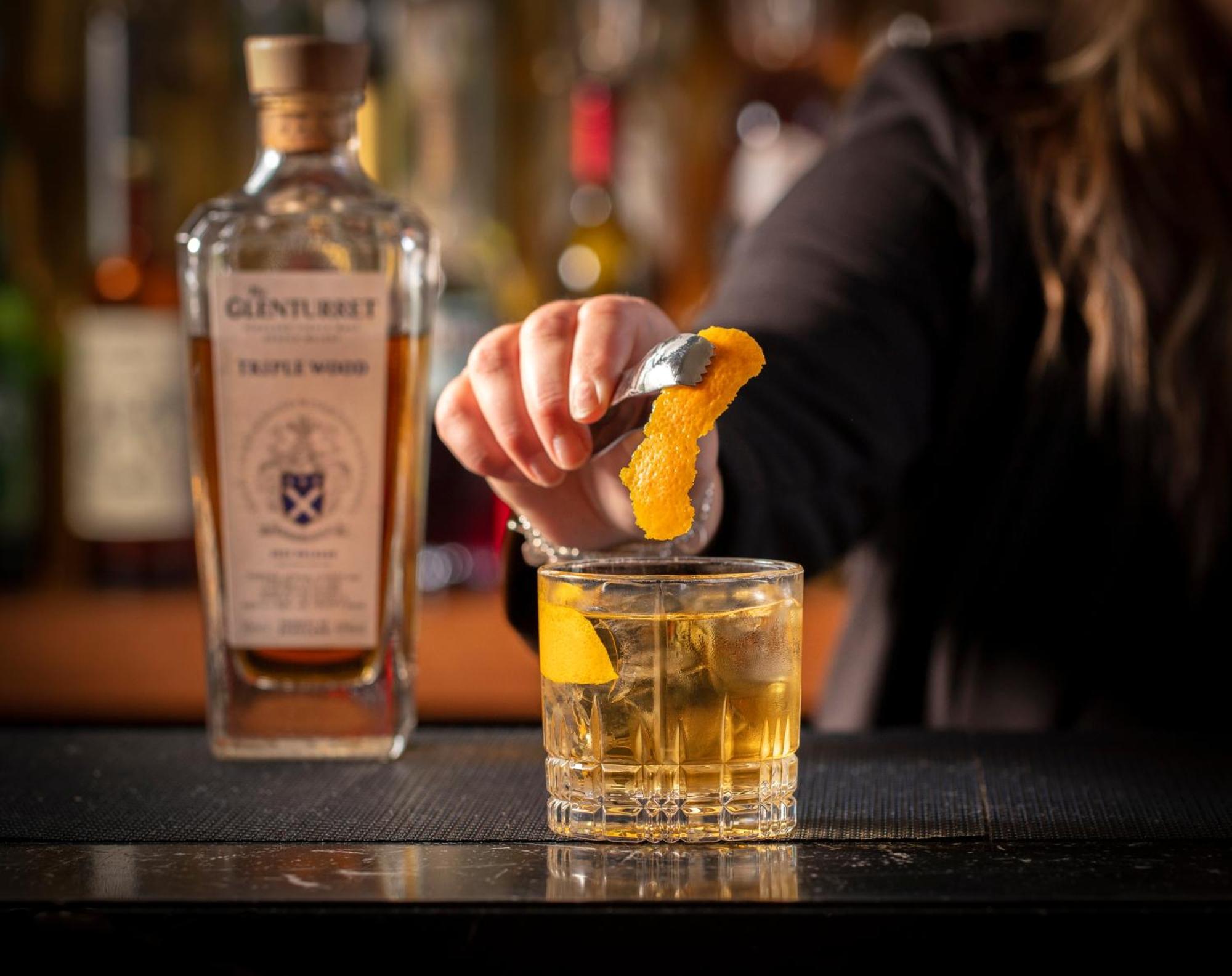 Schloss Roxburghe, Part Of Destination By Hyatt 외부 사진 A bartender adding a lemon twist to a glass of GINfinity